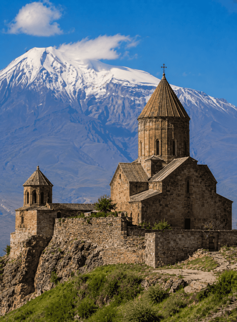 Historic church on a hill with Mount Ararat in the background, showcasing cultural heritage and natu.